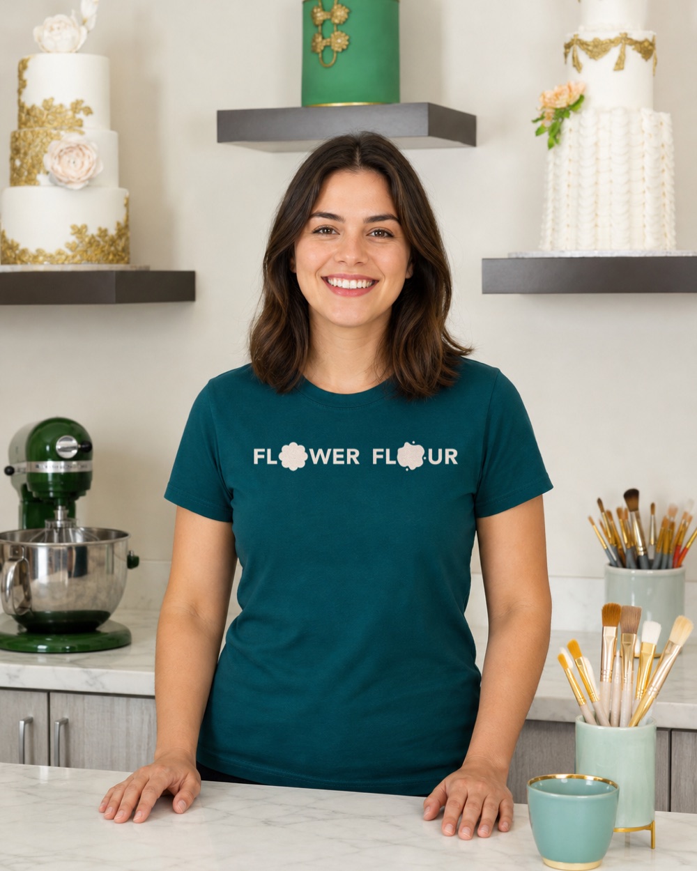 Model in the Flower Flour cake studio wearing the teal t-shirt with the blush wordmark