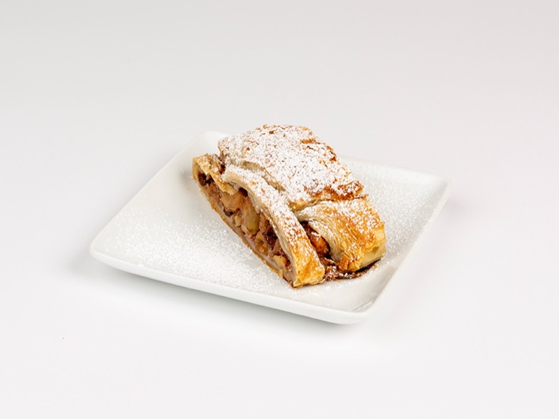 A slice of apple strudel dusted with powdered sugar
