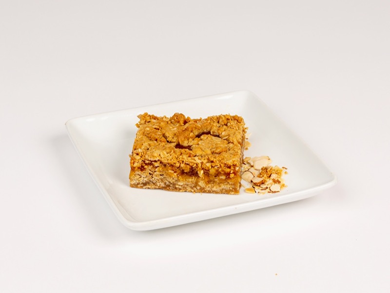 An apricot oatmeal bar on a white plate