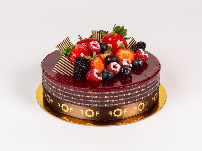 Ravishing raspberry cake with a glossy dark red top and fresh berries