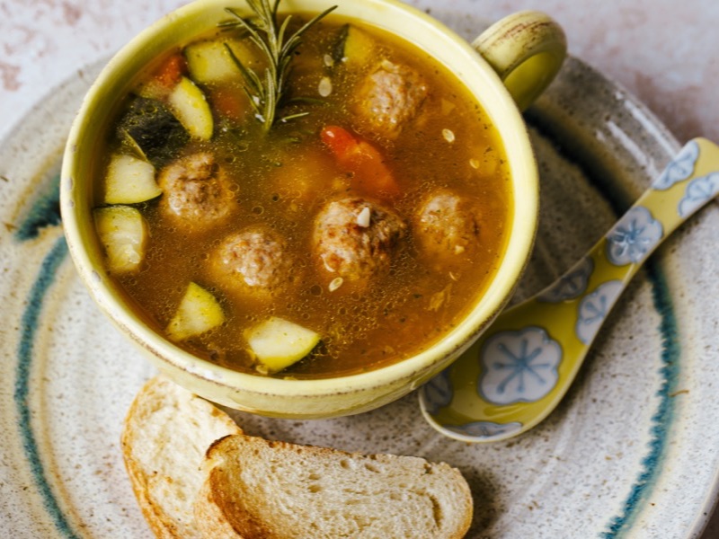 A cup of vegetable soup with bread