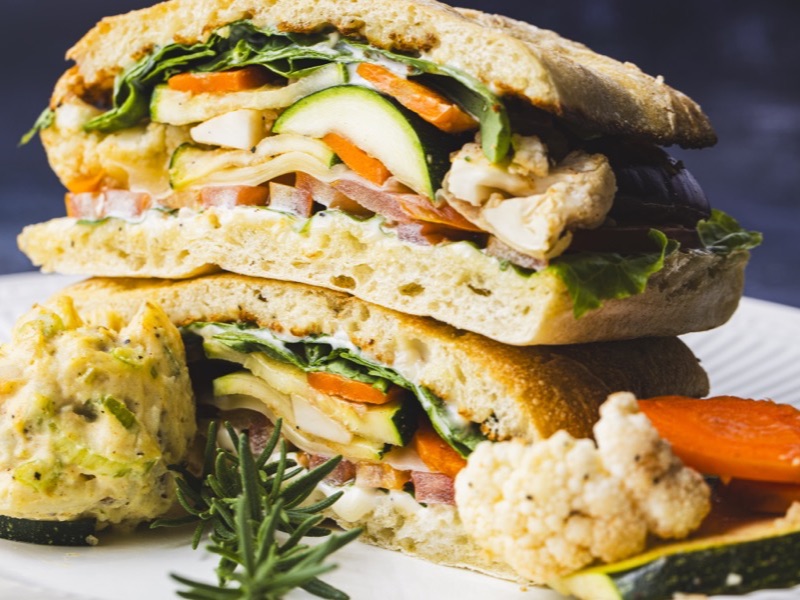 A grilled vegetarian panini with Swiss cheese, cut and stacked